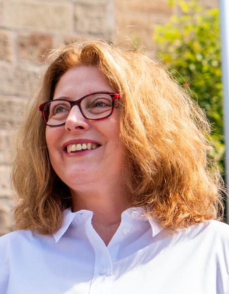 Pia Heuer, Pfarrsekretärin, lächelt im Freien
