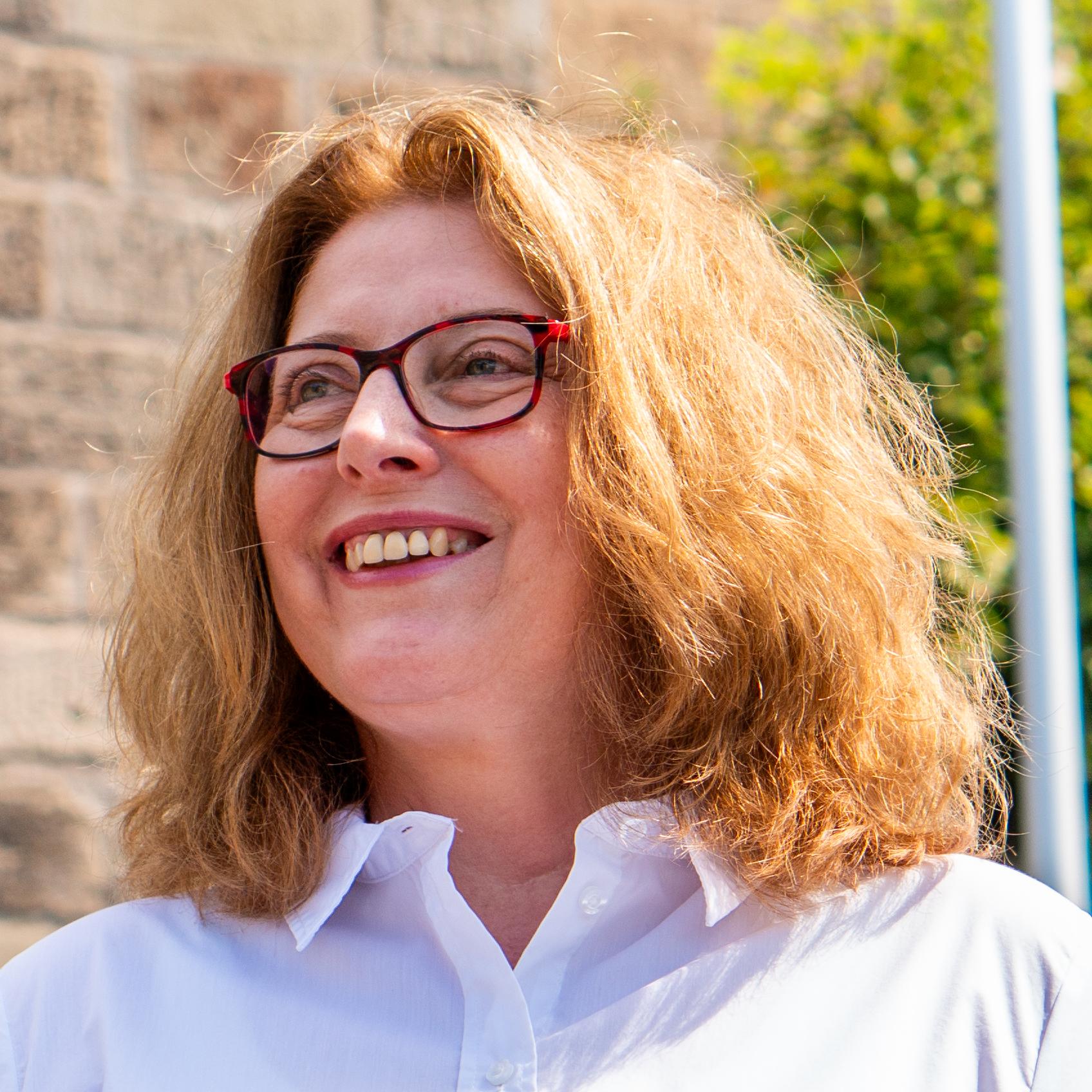 Pia Heuer, Pfarrsekretärin, lächelt im Freien